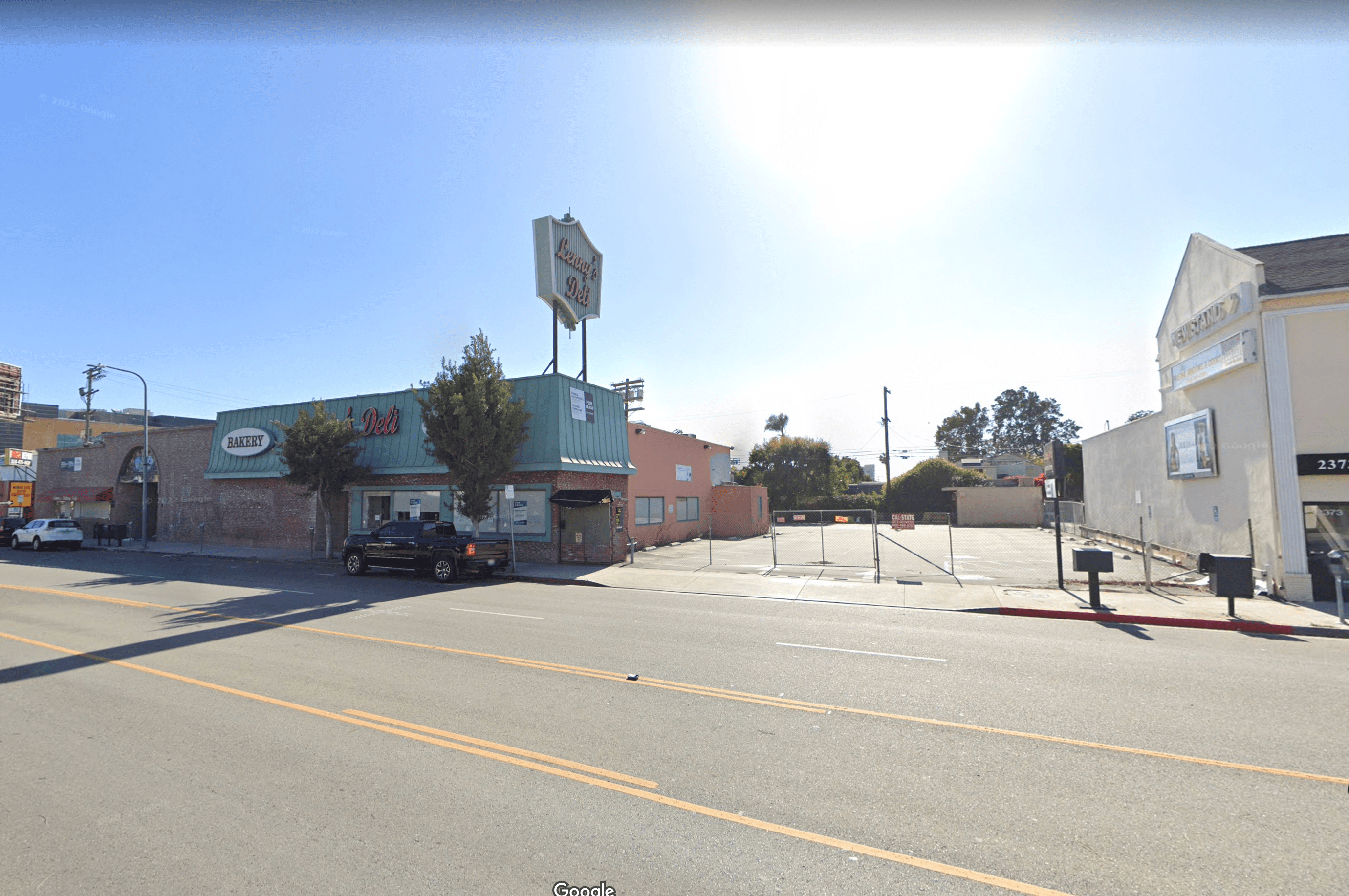 A street in West LA with commercial businesses and parking lots.