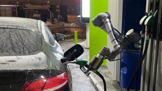 a robot arm pumping gas into a car