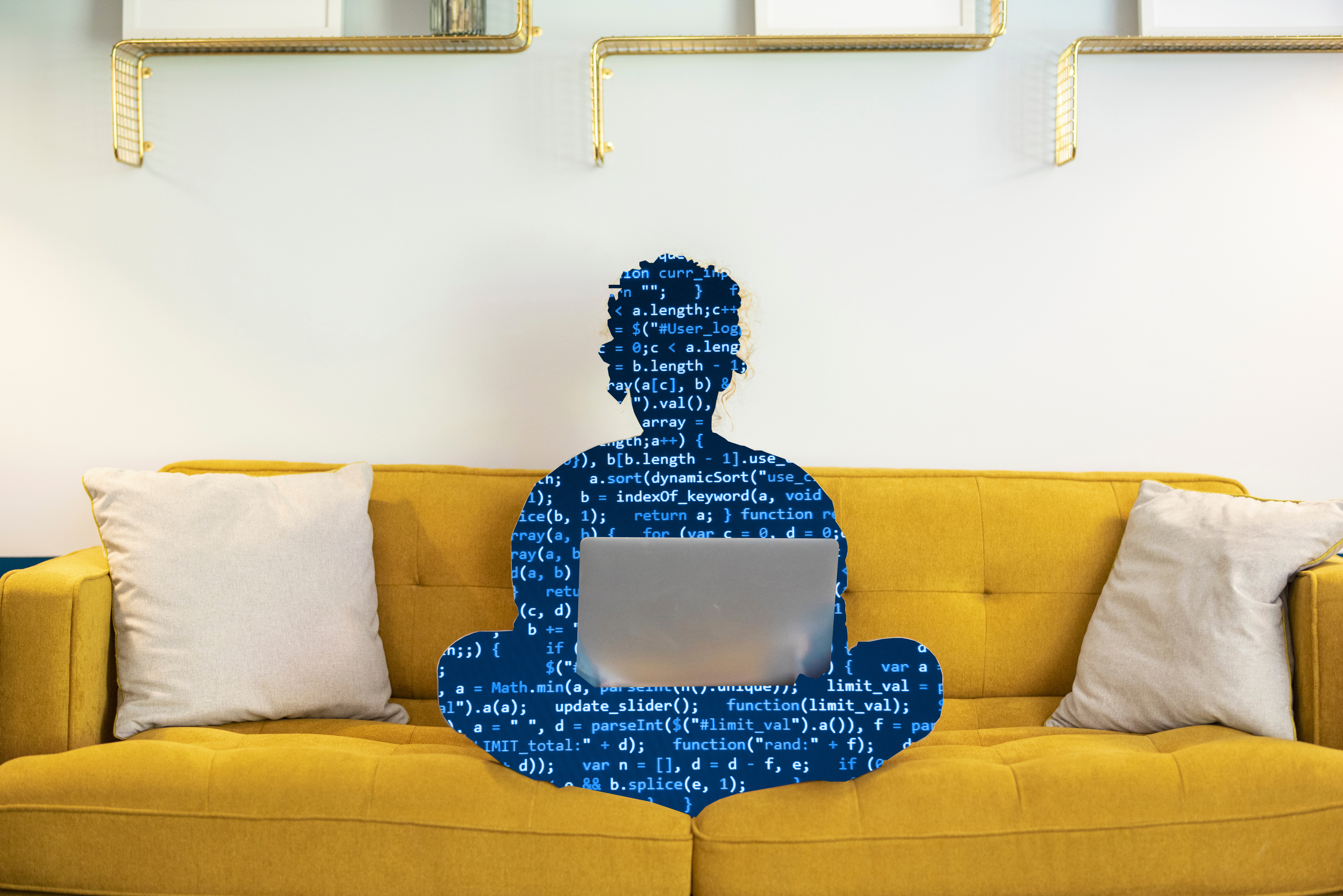 a silhouette of a person on a couch using a laptop