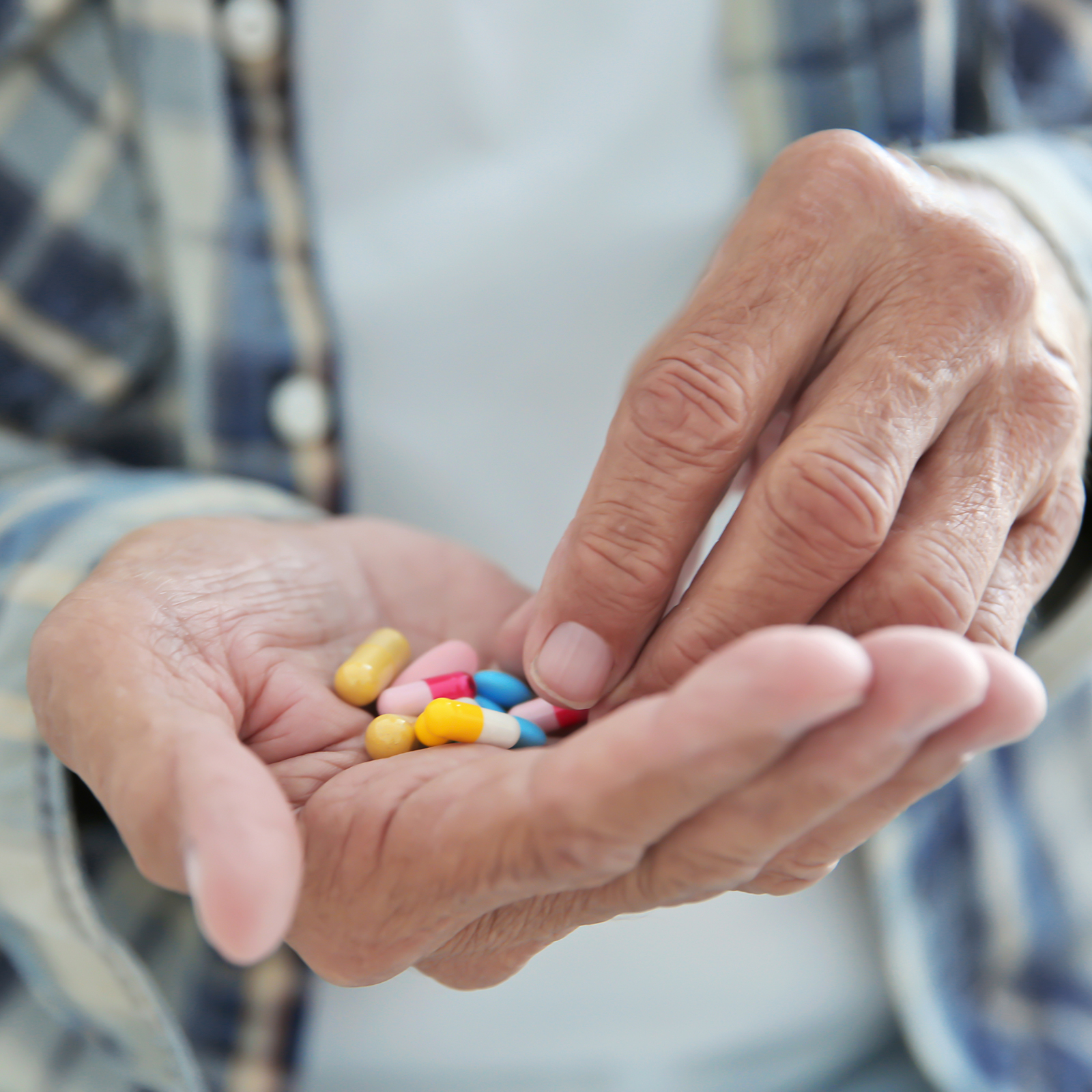 a close up of multiple types of pills in a hand