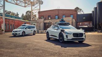 two of waymo's autonomous cars in a lot